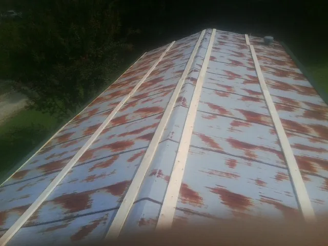 Rusted metal roof panels with new wood purlins before replacement — Storm Damage Roof Repair in Stoneham by Roofing Brothers